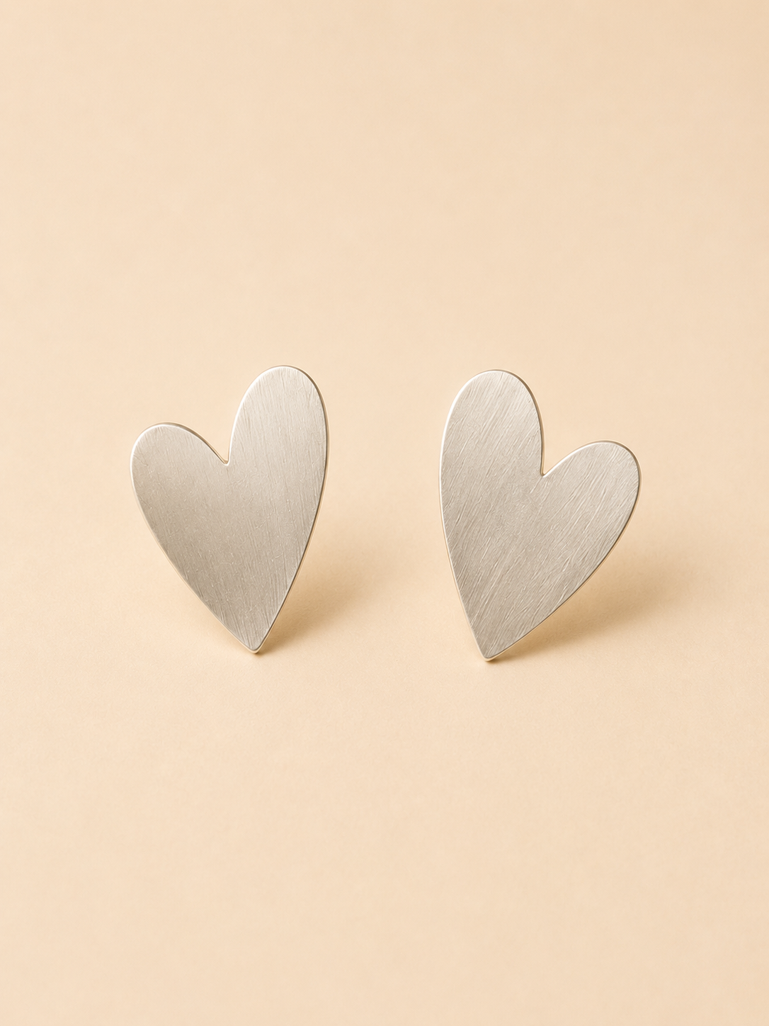 Aretes pegados corazón satinado de costado