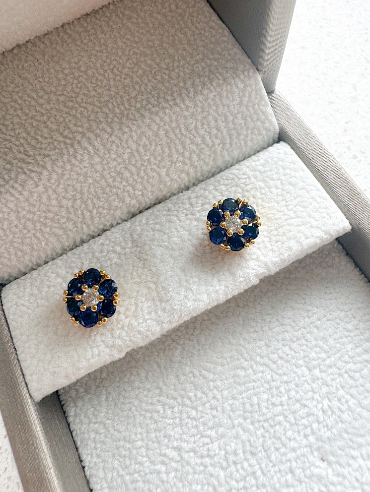 Aretes pegados círculo con circones azules y blanco en medio