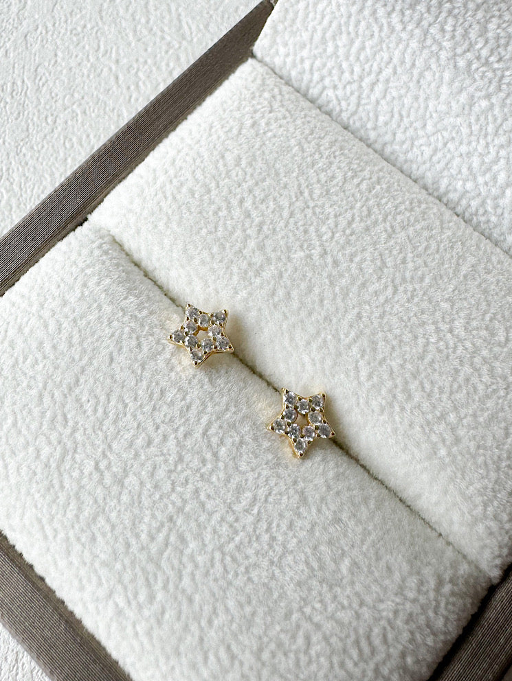 Aretes pegados estrella calada con seguro de bebé