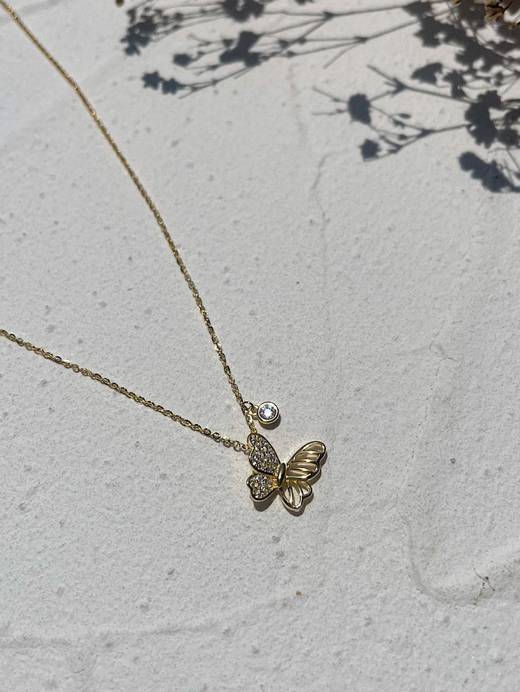 Cadena con dije mariposa de costado