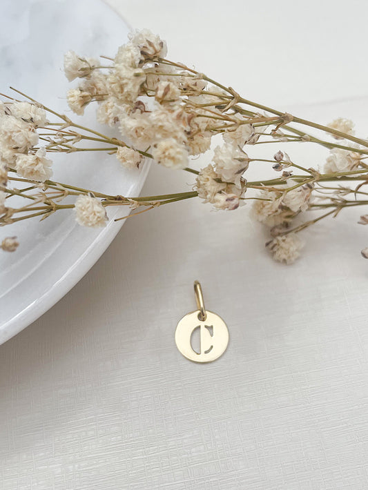 Dije círculo con letra calada