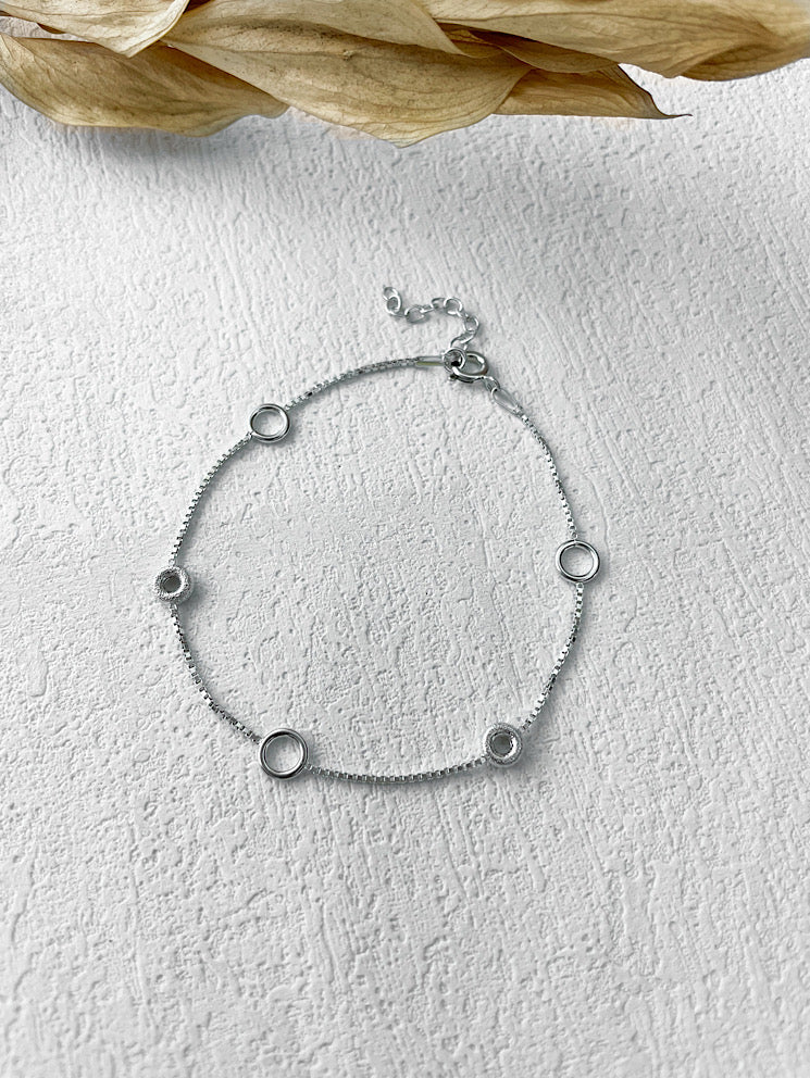 Pulsera delgadita con donas diamantadas y argollitas lisas