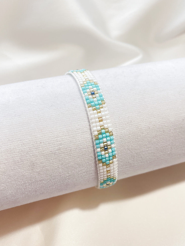 Pulsera tejida miyuki blanca con ojos turcos celestes