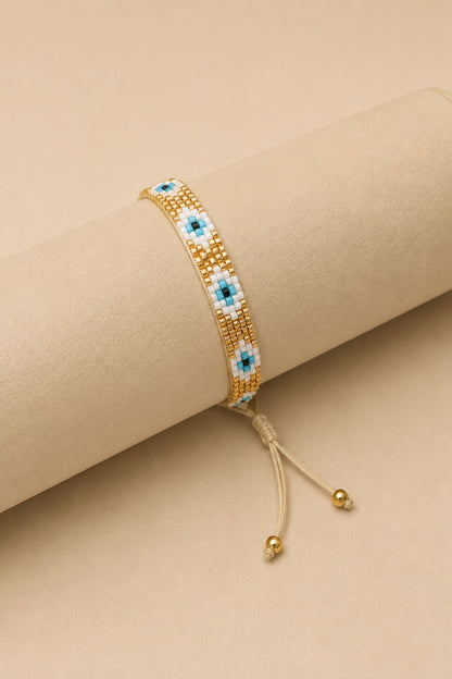 Pulsera tejida miyuki 6 filas dorada con ojos turcos blancos con celeste