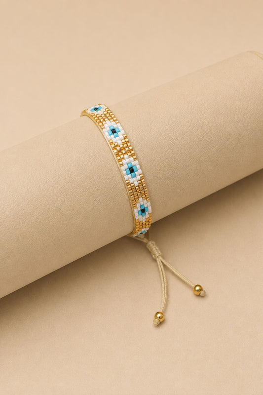 Pulsera tejida miyuki 6 filas dorada con ojos turcos blancos con celeste