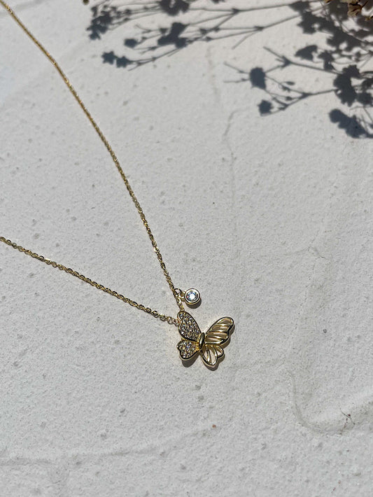 Cadena con dije mariposa de costado