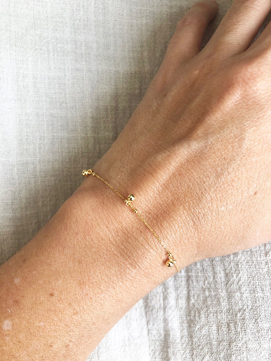 Pulsera delgada cadena con bolitas lisas colgando