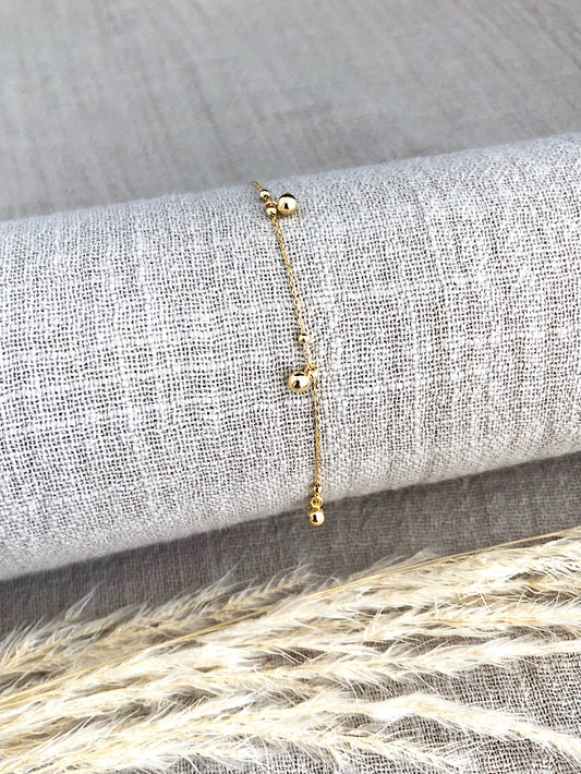 Pulsera delgada cadena con bolitas lisas colgando