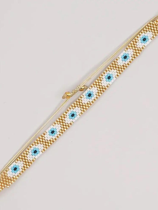 Pulsera tejida miyuki 6 filas dorada con ojos turcos blancos con celeste